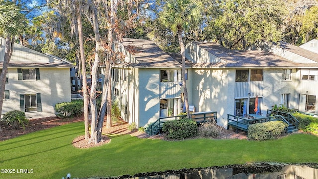 rear view of property featuring a yard and a deck