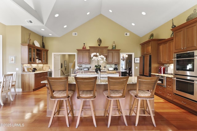 283 Seabrook Dr, Hilton Head Island, SC 29926 - kitchen featuring stainless steel double oven, a large island with sink, high vaulted ceiling, tasteful backsplash, and refrigerator