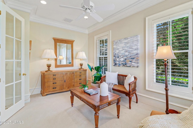 sitting room featuring baseboards, visible vents, a ceiling fan, light colored carpet, and ornamental molding