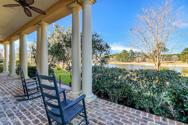 view of patio featuring a water view and a ceiling fan