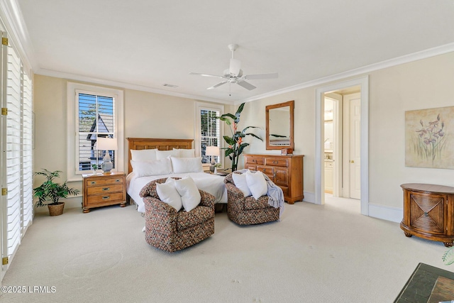 carpeted bedroom featuring ceiling fan, visible vents, baseboards, ornamental molding, and ensuite bath