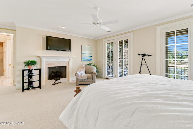 carpeted bedroom featuring ornamental molding, access to exterior, multiple windows, and a tile fireplace