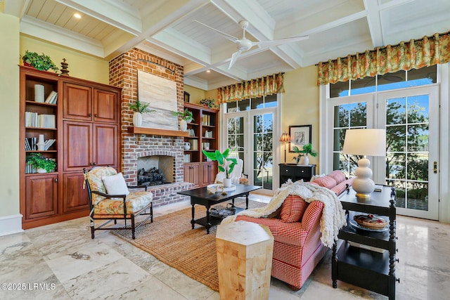 living area featuring beamed ceiling, coffered ceiling, a fireplace, and a wealth of natural light