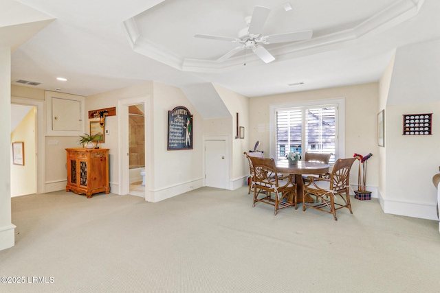 dining space featuring light colored carpet, a raised ceiling, visible vents, and baseboards