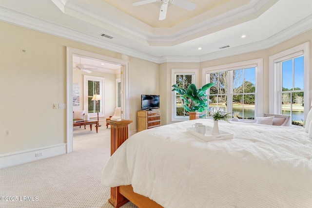 bedroom featuring visible vents, ornamental molding, a tray ceiling, and light colored carpet