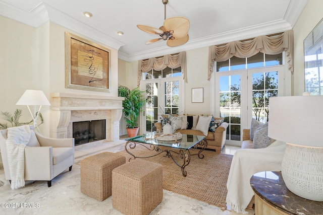 living room featuring ceiling fan, a premium fireplace, and crown molding