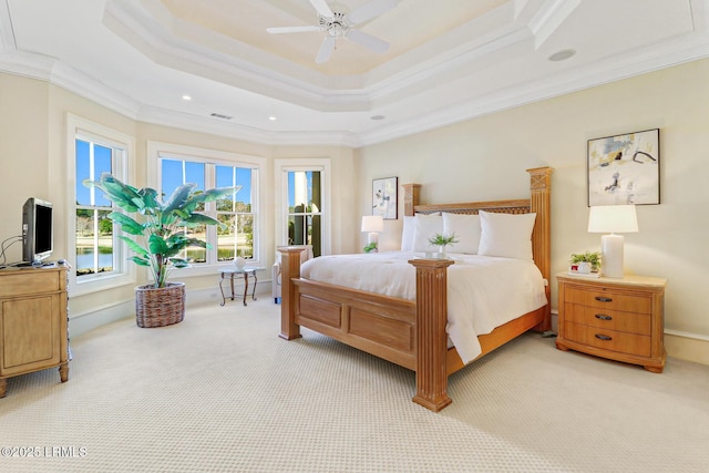 bedroom featuring a tray ceiling, light colored carpet, visible vents, ornamental molding, and baseboards