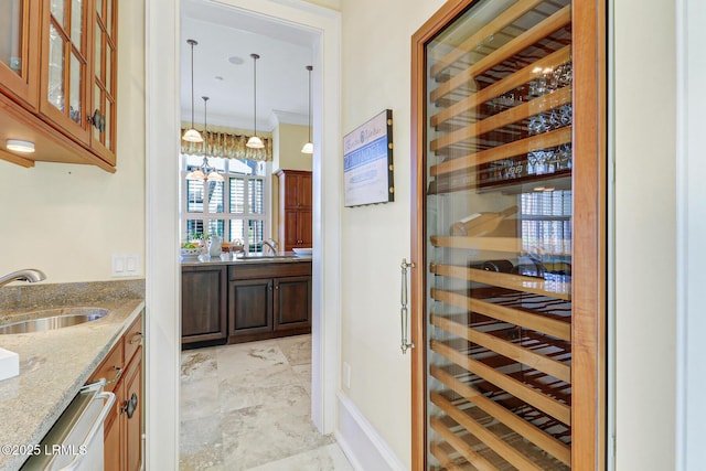 wine area featuring beverage cooler, ornamental molding, and a sink