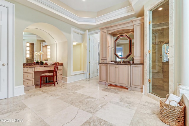 full bath featuring a stall shower, baseboards, a raised ceiling, crown molding, and vanity