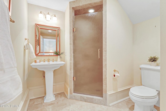 bathroom with a shower stall, toilet, and tile patterned floors