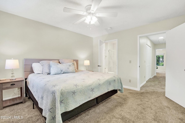 bedroom with ceiling fan, ensuite bath, and light carpet