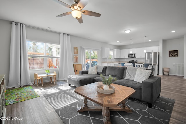 living room featuring visible vents, baseboards, recessed lighting, wood finished floors, and a ceiling fan