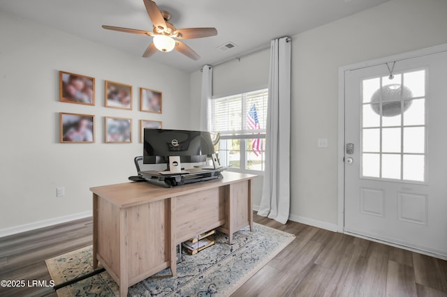 office area with wood finished floors, a ceiling fan, visible vents, and baseboards