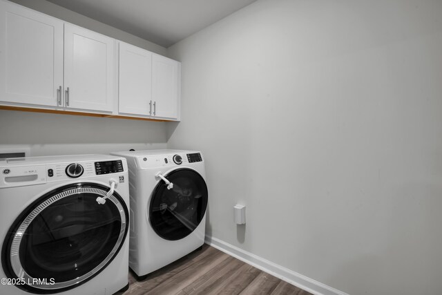 laundry area featuring washer and dryer, wood finished floors, cabinet space, and baseboards