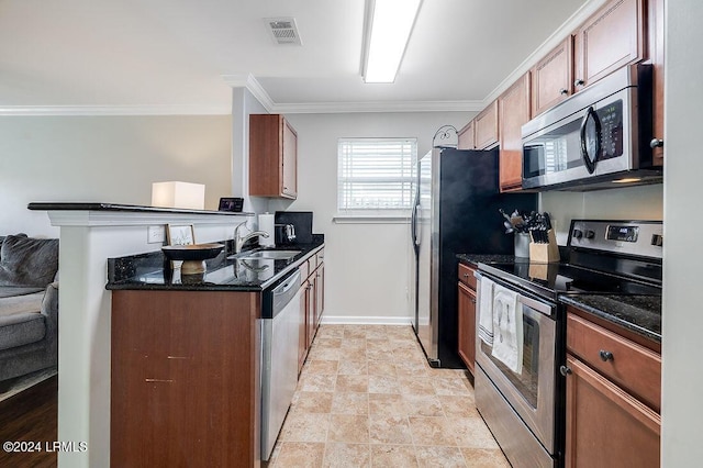 kitchen featuring appliances with stainless steel finishes, sink, dark stone counters, ornamental molding, and kitchen peninsula