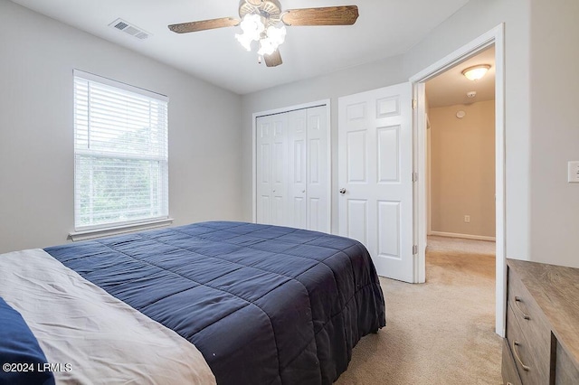 carpeted bedroom with ceiling fan and a closet