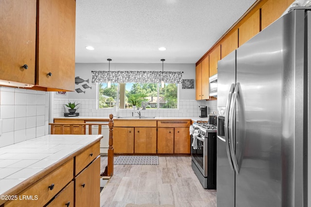 36 Stuart Town Ct, Beaufort, SC 29902 - kitchen featuring stainless steel appliances, tile counters, brown cabinets, backsplash, and recessed lighting