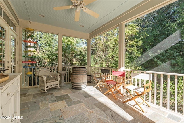 unfurnished sunroom with ceiling fan