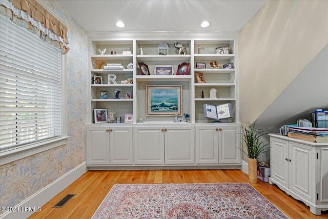 interior space with built in shelves and wood-type flooring