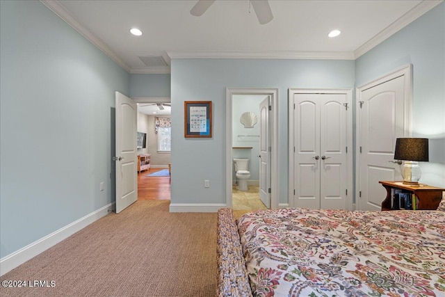 bedroom featuring ceiling fan, ornamental molding, ensuite bathroom, and light colored carpet