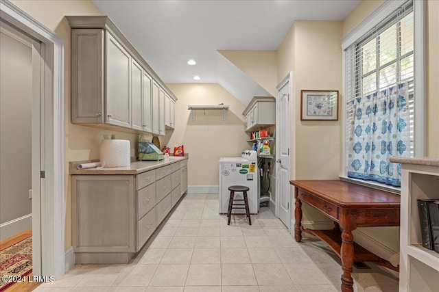 clothes washing area featuring independent washer and dryer, cabinets, and light tile patterned floors