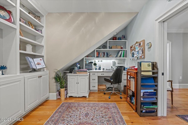 home office with ornamental molding, built in features, and light hardwood / wood-style flooring