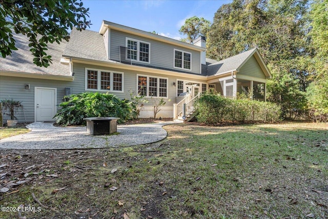 back of house with a yard and a fire pit