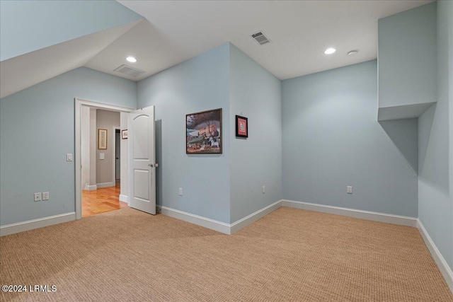 interior space featuring light colored carpet and vaulted ceiling