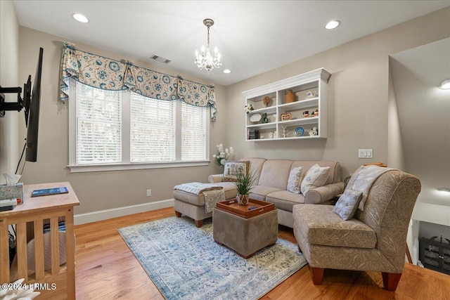 living room with a notable chandelier and light hardwood / wood-style floors