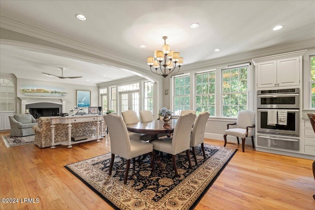 dining area featuring ceiling fan with notable chandelier, ornamental molding, and light wood-type flooring