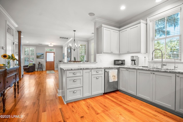 1108 12th St, Port Royal, SC 29935 - kitchen featuring a peninsula, light wood-style flooring, stainless steel dishwasher, decorative backsplash, and ornamental molding