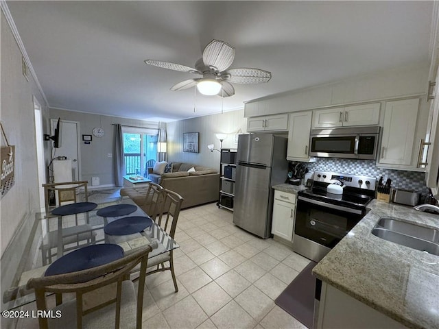 kitchen with stainless steel appliances, sink, decorative backsplash, and white cabinets