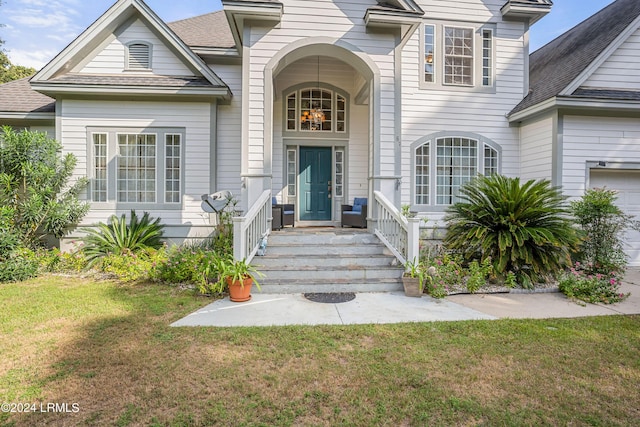 view of exterior entry featuring a lawn