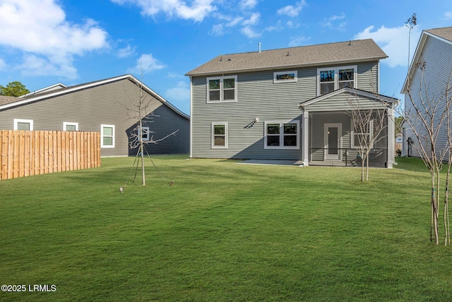 rear view of house featuring a sunroom, a patio area, a lawn, and fence