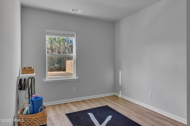 interior space with light wood-type flooring, visible vents, and baseboards