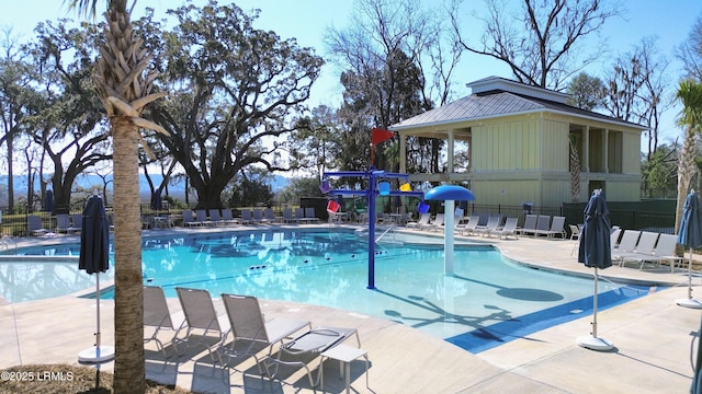 pool with a patio area and fence