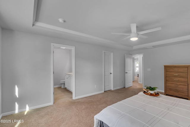 bedroom featuring baseboards, a raised ceiling, connected bathroom, and light colored carpet