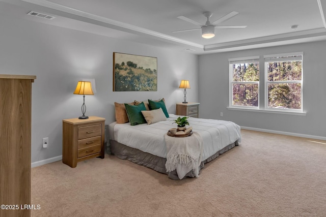 bedroom with light carpet, baseboards, visible vents, a raised ceiling, and a ceiling fan