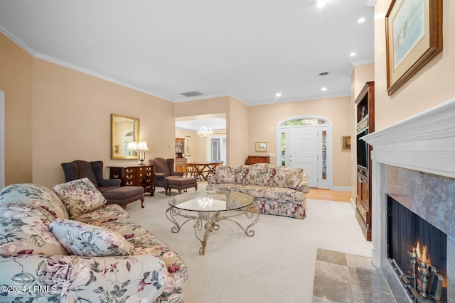 carpeted living room with crown molding, a fireplace, and a chandelier