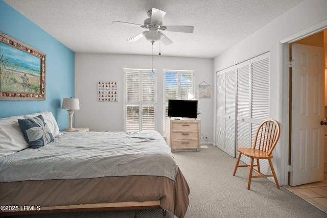 bedroom featuring a textured ceiling, a ceiling fan, carpet flooring, and a closet