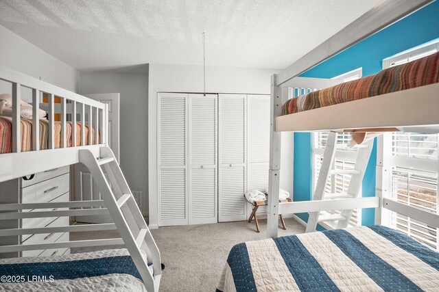 bedroom featuring a textured ceiling, a closet, and carpet