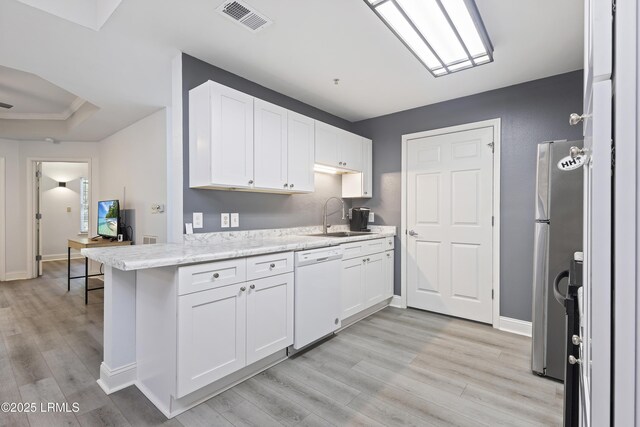 4924 Bluffton Pkwy Unit 18-106, Bluffton, SC 29910 - kitchen with dishwasher, a sink, light wood-style floors, white cabinets, and freestanding refrigerator