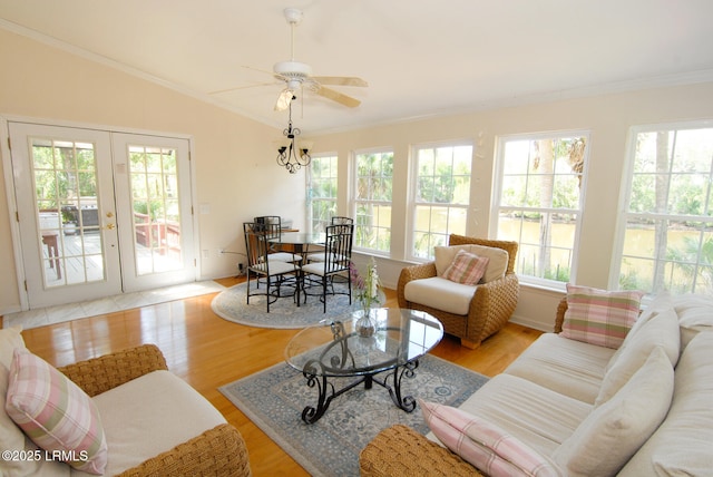living area with crown molding, wood finished floors, french doors, a ceiling fan, and vaulted ceiling
