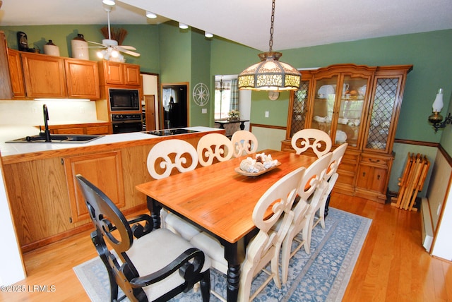 dining space featuring light wood-style flooring, ceiling fan, and lofted ceiling