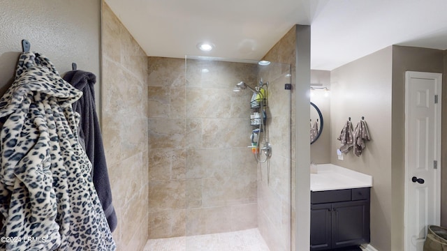 bathroom with vanity and tiled shower