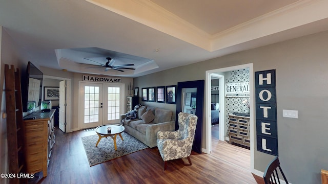 living room featuring a raised ceiling, hardwood / wood-style flooring, ceiling fan, and french doors