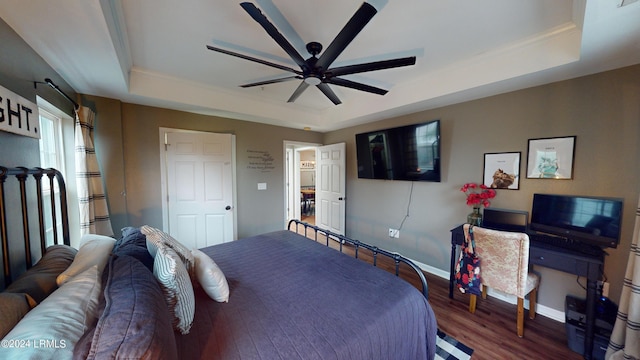 bedroom featuring ceiling fan, dark hardwood / wood-style floors, and a raised ceiling