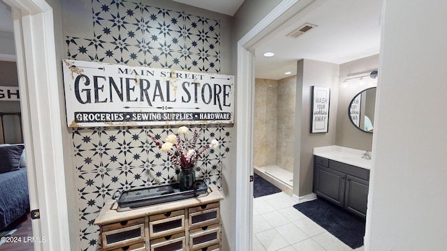 bathroom with vanity, tiled shower, and tile patterned floors