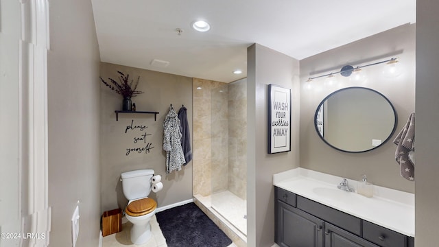 bathroom featuring tile patterned flooring, vanity, toilet, and a tile shower