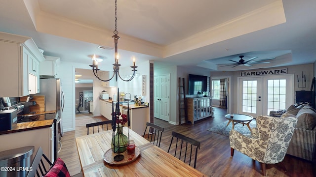 dining room featuring french doors, dark hardwood / wood-style floors, ornamental molding, and a tray ceiling